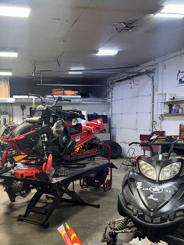 TVS Power red skidoo up on hoist for repair